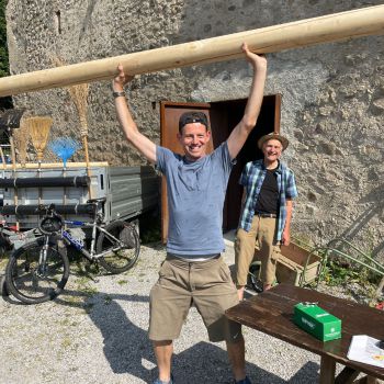 Foto eines Mitarbeiters, der eine Wegweiser-Stange hochstemmt